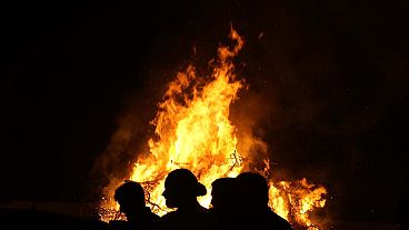 Young men stand in front of the traditional Easter bonfire, or lambradjia, during Orthodox easter celebrations in Cyprus.