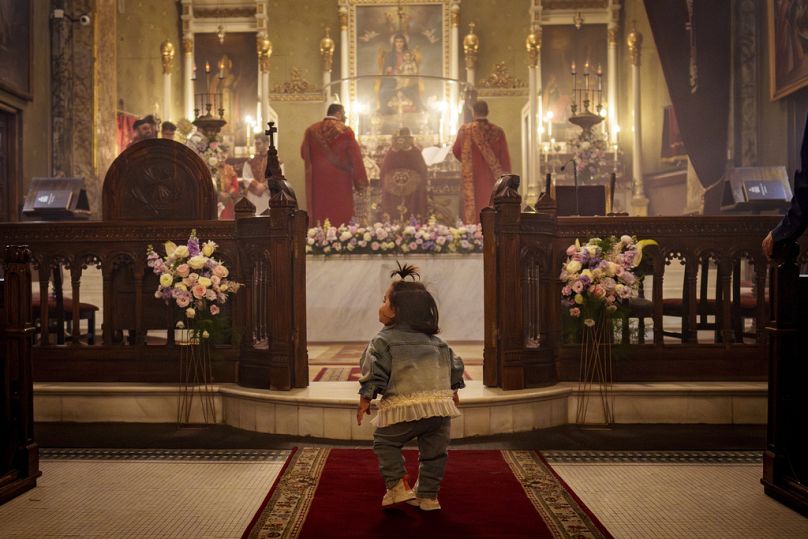 A baby girl plays during an Orthodox Easter religious service at the Armenian cathedral in Bucharest, Romania on Saturday, 4 May.