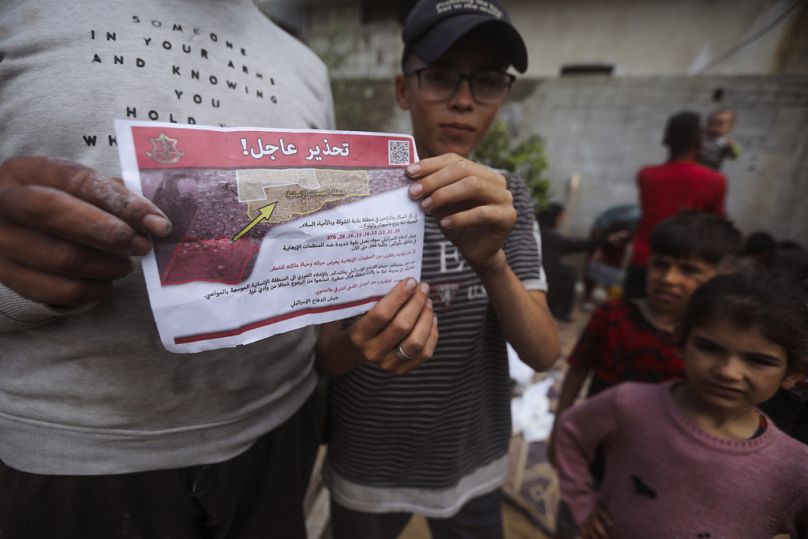 Palästinenser halten Flugblätter, die von israelischen Flugzeugen abgeworfen wurden und sie auffordern, vor einer israelischen Militäroperation zu evakuieren, 6. Mai 2024.