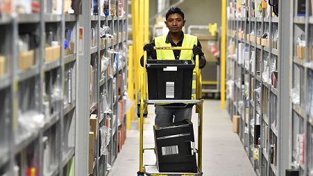 Un ouvrier collecte des marchandises pour les commandes dans un entrepôt du centre logistique d'Amazon en Allemagne.