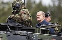 المستشار الألماني أولاف شولتس يركب مركبة عسكرية مدرعة خلال التدريبات العسكرية الليتوانية الألمانية