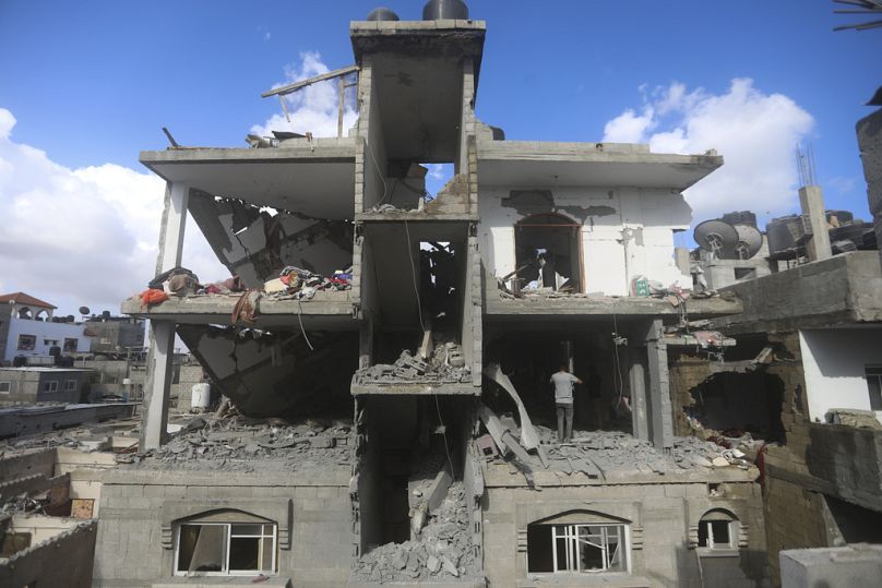 Ciudadanos palestinos observan la destrucción tras un ataque israelí contra un edificio residencial en Rafah, Franja de Gaza, el martes 7 de mayo de 2024.