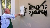 El presidente del Consejo Nacional, Wolfgang Sobotka cubren una pintada antisemita en la fachada de una tienda regentada por judíos en Viena.