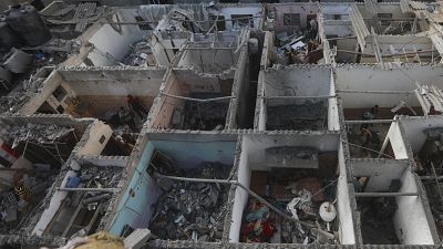 فلسطينيون ينظرون إلى الدمار بعد غارة إسرائيلية على مبنى سكني في رفح، قطاع غزة، الثلاثاء، 7 مايو، 2024.