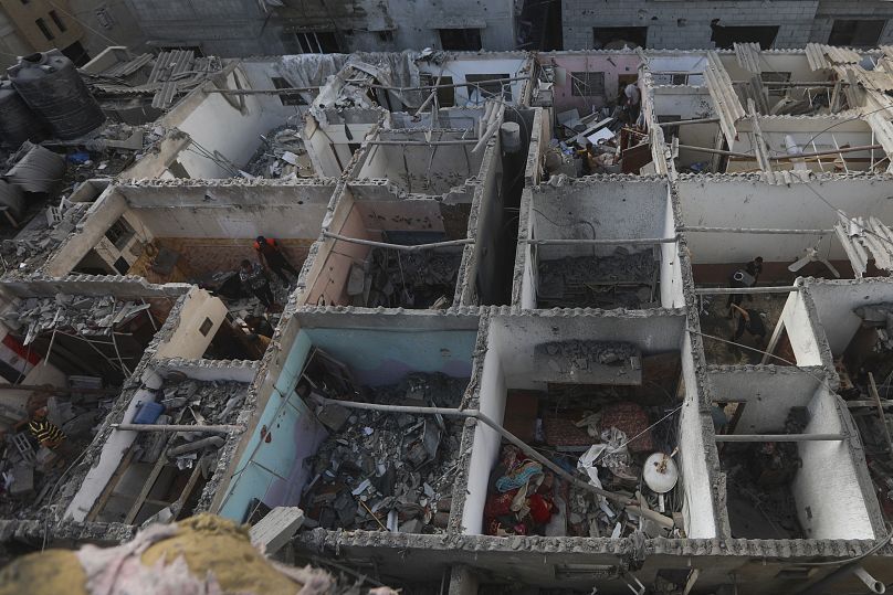 Palestinians look at the destruction after an Israeli strike on residential building in Rafah, Gaza Strip, in May.