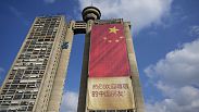 Workers hang on ropes to install a giant Chinese national flag on a skyscraper that is a symbolic gateway leading into the city from the airport, in Belgrade, Serbia