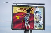 Arbeiter kleben eine chinesische Nationalflagge auf eine Plakatwand in Belgrad, Serbien, Dienstag, 7. Mai 2024.