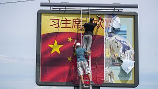 Arbeiter kleben eine chinesische Nationalflagge auf eine Plakatwand in Belgrad, Serbien, Dienstag, 7. Mai 2024.