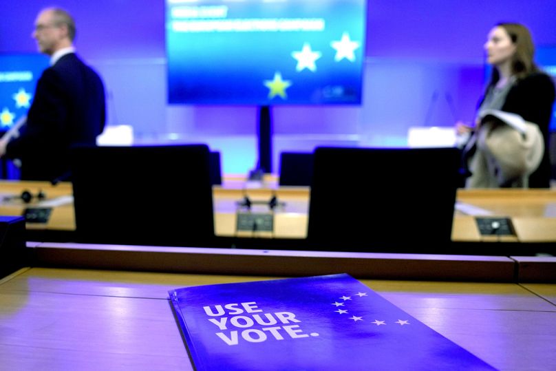 Two presenters arrive for a media briefing concerning the upcoming European elections at the European Parliament in Brussels, April 2024