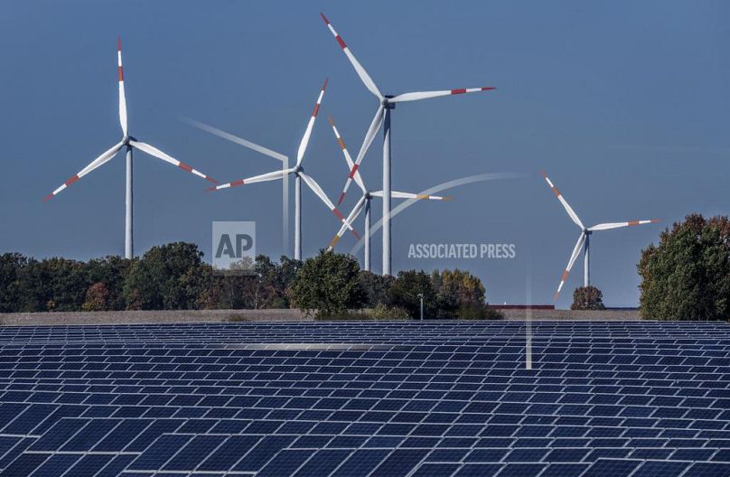 Wind turbines turn behind a solar farm in Rapshagen, Germany.
