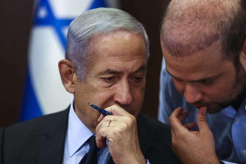 Israeli Prime Minister Benjamin Netanyahu, left, speaks with an advisor as he convenes a cabinet meeting at the Prime Minister's office in Jerusalem, May 2023