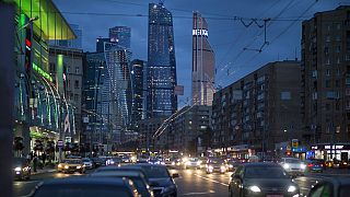 Traffic fills the multi-lane highway, along a main thoroughfare in Moscow, with the modern city skyscrapers illuminating the skyline in Moscow, Russia, Friday, July 8, 2016.