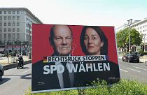 EU voting campaign with German Chancellor Olaf Scholz and SPD lead EU candidate Katarina Barley on defaced placard with 'stop rightward shift' motto 