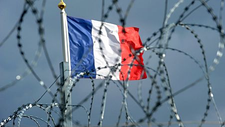 پرچم فرانسه در پشت سیم خاردار، عکس تزیینی است