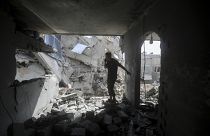 Palestinians look at the destruction after an Israeli strike on residential building in Rafah, May 7, 2024