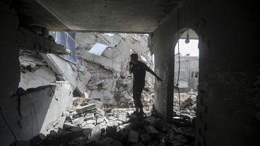 Palestinians look at the destruction after an Israeli strike on residential building in Rafah, May 7, 2024