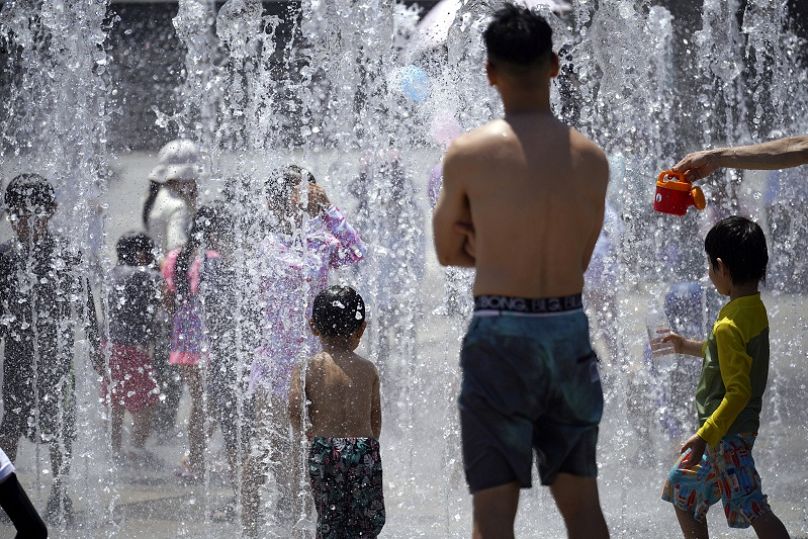 imagen de archivo. La gente se refresca en una fuente bajo un clima cálido y soleado el lunes 17 de julio de 2023 en Yokohama, cerca de Tokio