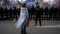 A demonstrator stands wrapped in an Argentine flag during a protest against food scarcity at soup kitchens and economic reforms proposed by President Javier Milei in Buenos A
