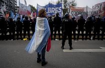 A demonstrator stands wrapped in an Argentine flag during a protest against food scarcity at soup kitchens and economic reforms proposed by President Javier Milei in Buenos A