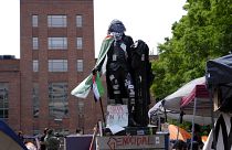 تمثال لجورج واشنطن مغطى بملصقات وعلم فلسطين وكوفية بالقرب من مخيم للطلاب في حرم جامعة جورج واشنطن. 2024/05/03 