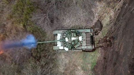 A Russian tank fires its cannon at Ukrainian troops from a position near the border with Ukraine in the Belgorod region, Russia