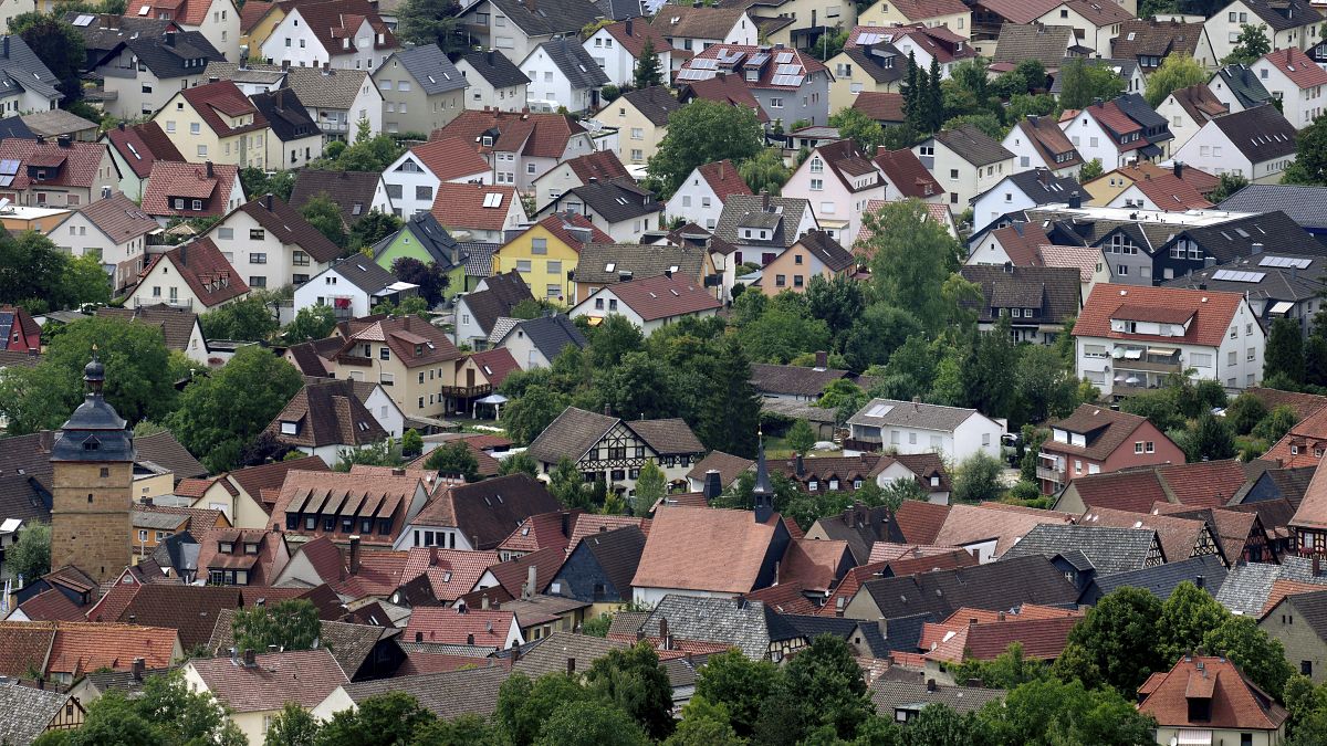 Жилые дома в городе Бад Штаффельштайн на фоне холма Штаффельберг в Германии