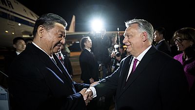 In this image provided by the Hungarian Prime Minister's Office, Chinese President Xi Jinping, left, shakes hands with Hungarian Prime Minister Viktor Orban as