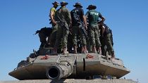 جنود إسرائيليون فوق مركبة عسكرية مدرعة في منطقة تجمع بالقرب من الحدود بين إسرائيل وغزة، 8 مايو/أيار 2024.