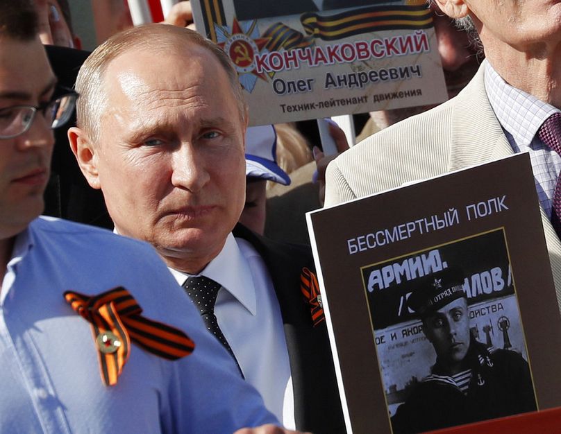 Der russische Präsident Wladimir Putin, rechts, hält ein Porträt seines Vaters Wladimir Spiridonowitsch Putin während des Militärmarsches am 9. Mai 2018.