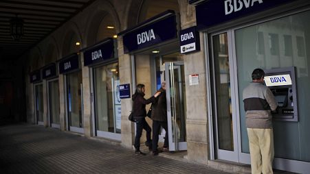 Un hombre utiliza un cajero automático en un banco de Pamplona (norte de España)