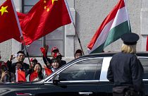 People wave Chinese and Hungarian flags for the Chinese President Xi Jinping outside the Buda Castle in Budapest, 9 May 2024