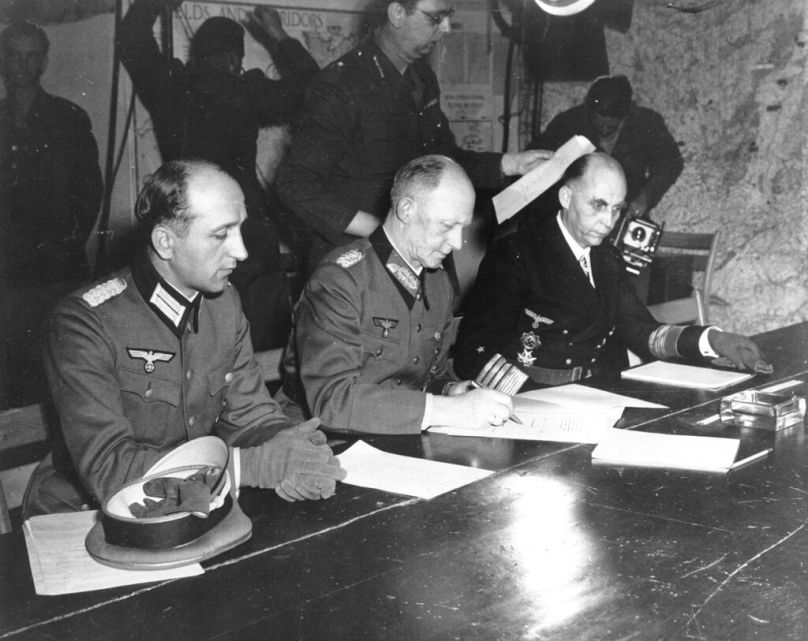 General Alfred Jodl (ortada), Mayıs 1945&apos;te Rheims kentindeki Başkomutan Eisenhowers karargâhında tüm silahlı Alman kuvvetlerinin kayıtsız şartsız teslimini imzalarken
