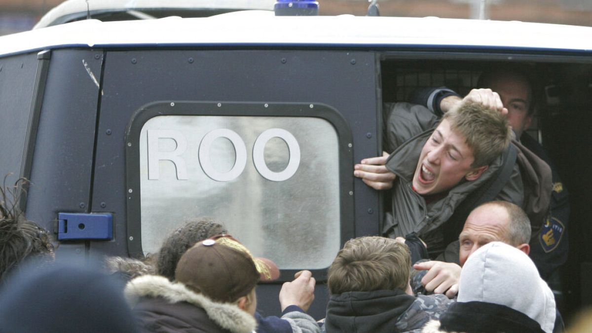 ضباط الشرطة يعتقلون طالبًا خلال أعمال شغب في أمستردام، هولندا