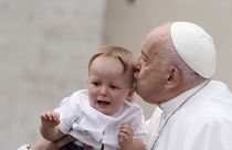 Pope Francis kisses a child at the end of his weekly general audience in St. Peter's Square, at the Vatican, Wednesday, May 8, 2024