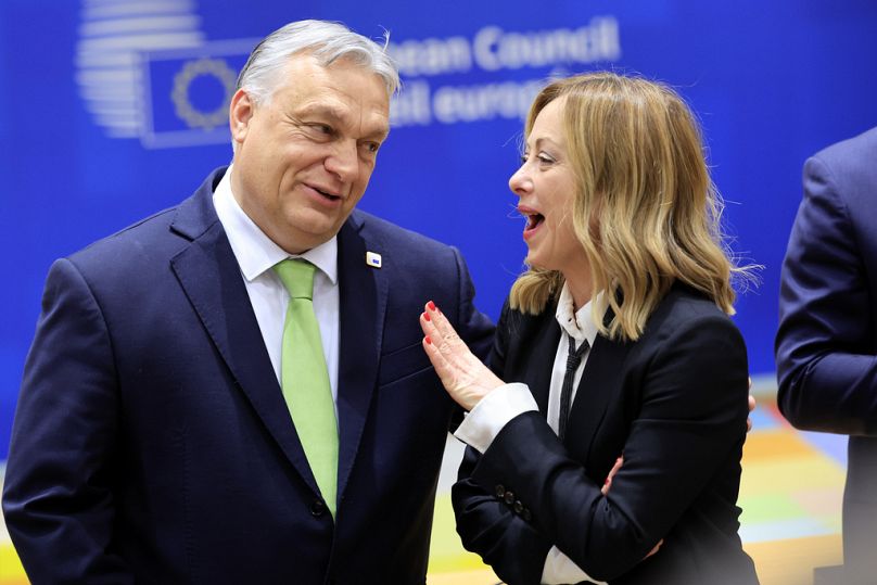 Hungary's Prime Minister Viktor Orban, left, speaks with Italy's Prime Minister Giorgia Meloni during a round table meeting at an EU Summit in Brussels, March 2024