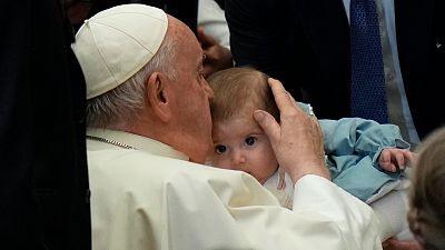 البابا فرنسيس يقبّل طفلاً خلال لقاء مع أطفال من جميع أنحاء العالم في قاعة بولس السادس في الفاتيكان، 6 نوفمبر/تشرين الثاني 2023.