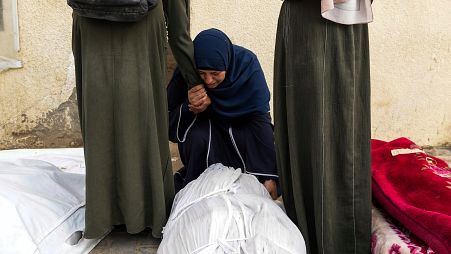 نساء فلسطينيات أمام مشرحة مستشفى الأقصى في دير البلح يبكين أقاربهن الذين قتلوا في القصف الإسرائيلي