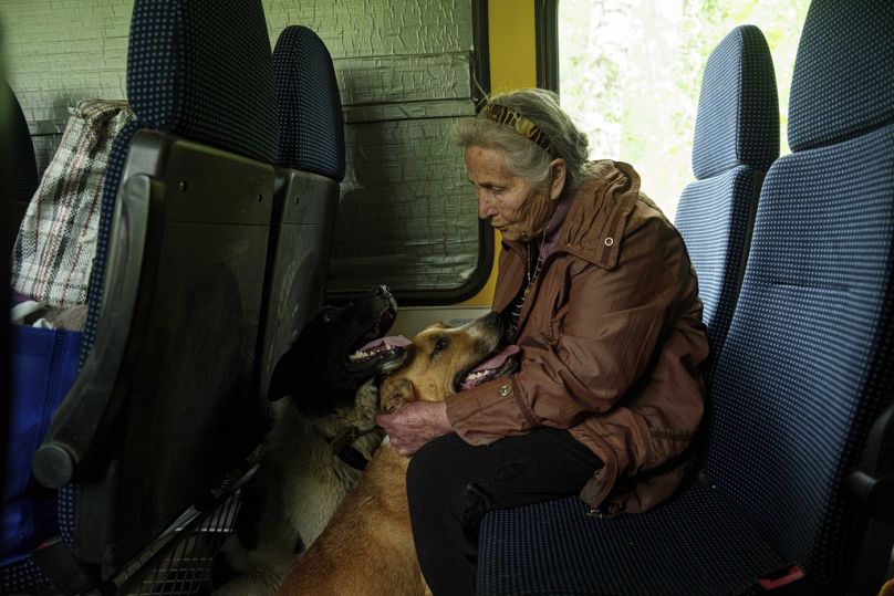 Eine ältere Frau nimmt ihren Hund mit bei der Evakuierung aus Wowtschansk