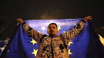 Um manifestante segura uma bandeira da UE durante uma manifestação de protesto contra "a lei russa" em Tbilisi, 11 de maio de 2024