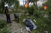 A police officer runs in front on burning house destroyed by a Russian airstrike in Vovchansk, Ukraine