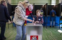 امرأة في مراكز التصويت مع طفليها 