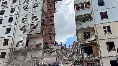Russian emergency services work at the scene of a partially collapsed block of flats authorities said was hit during an attack by Ukrainian shelling, in Belgorod, Russia