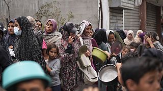 Palestinians line up for food distribution in Deir al Balah, Gaza, Friday, May 10, 2024.