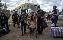 Die ukrainischen Behörden helfen einer älteren Frau.