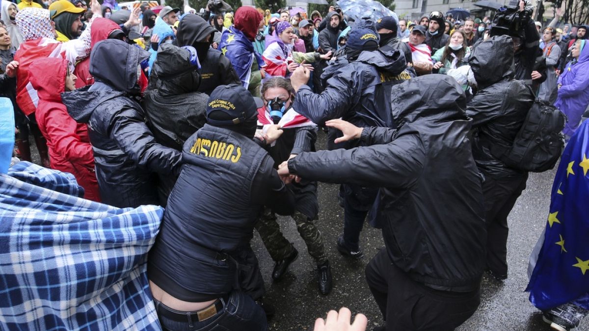Police try to detain demonstrators near the Parliament building during an opposition protest against "the Russian law" in Tbilisi, Georgia, on Monday, May 13, 2024.