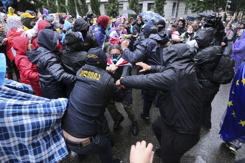 Police try to detain a demonstrator near the Parliament building during an opposition protest against "the Russian law" in the center of Tbilisi, Georgia, on Monday, 13May 24