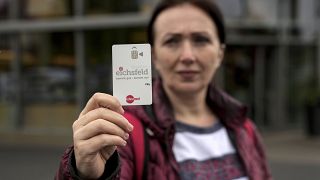 Эрдина Лака демонстрирует платёжную карту для просителей убежища, по которой она делает покупки в магазинах Айхсфельде в Германии. Она больше не платит наличными за продукты.