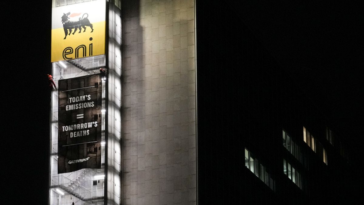 Greenpeace environmental organization activist unroll a banner on the ENI, Italian oil and gas company, headquarters building, in Rome, Tuesday, Dec. 5, 2023. 