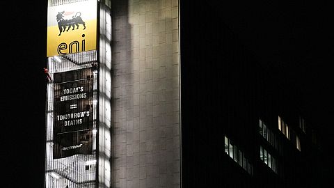 Greenpeace environmental organization activist unroll a banner on the ENI, Italian oil and gas company, headquarters building, in Rome, Tuesday, Dec. 5, 2023. 