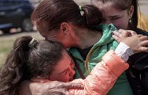 Khrystyna Pyimak, 11, hugs her mother Oksana Velychko, 42, after evacuation from Vovchansk, 12 May 2024